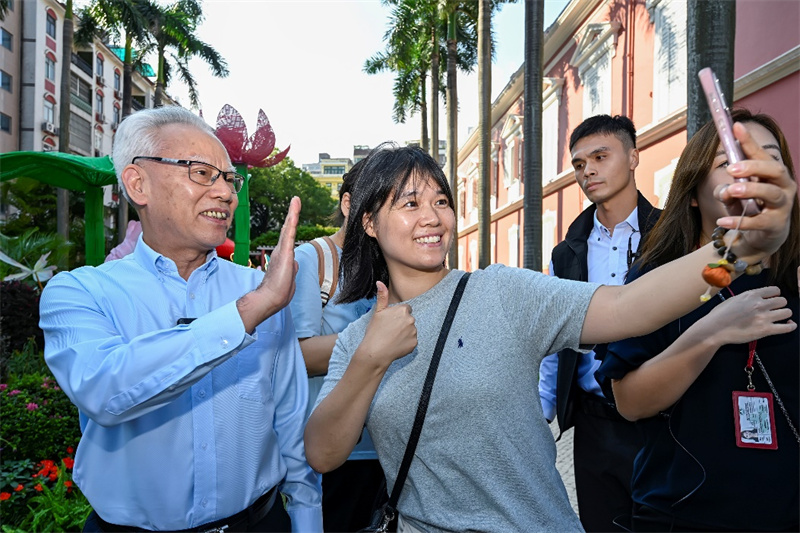 图为游客在政府总部开放日活动中见到岑浩辉并合影,游澳收获倍增。澳门特区政府新闻局供图
